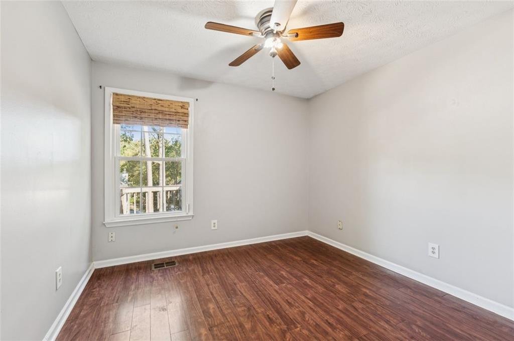 2470 Jakin Way Suwanee, GA 30024 - Photo 28 of 64 an empty room with wooden floor ceiling fan and windows