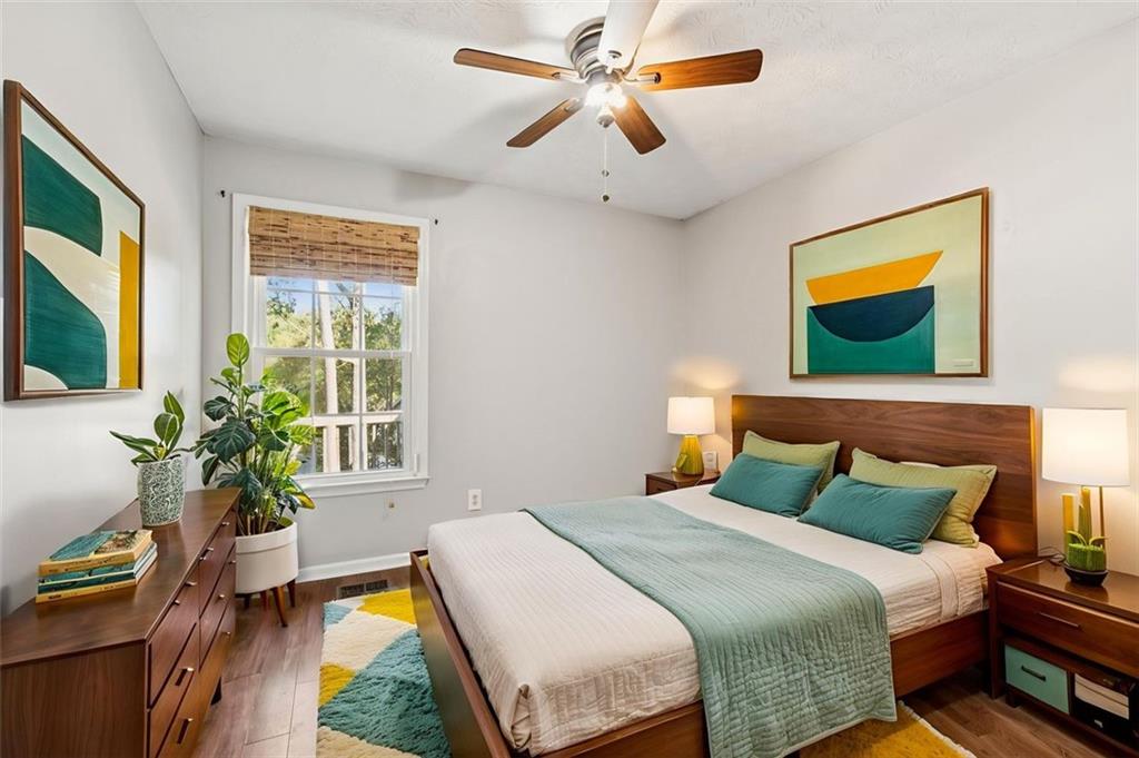 2470 Jakin Way Suwanee, GA 30024 - Photo 29 of 64 a bedroom with a bed a flat screen tv and a potted plant