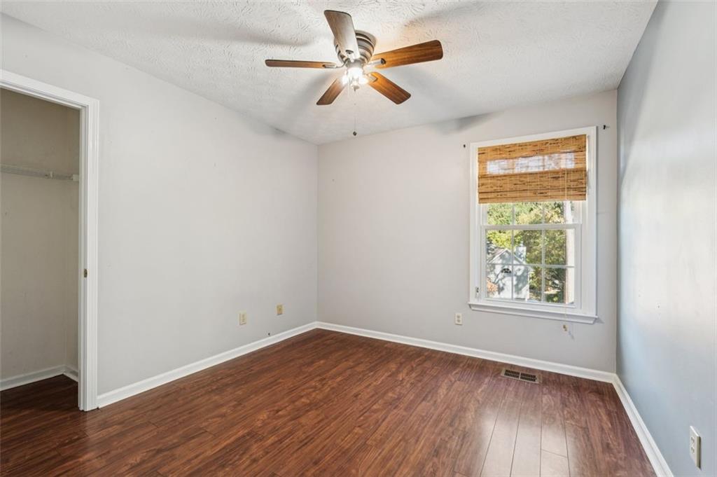 2470 Jakin Way Suwanee, GA 30024 - Photo 30 of 64 an empty room with wooden floor and windows