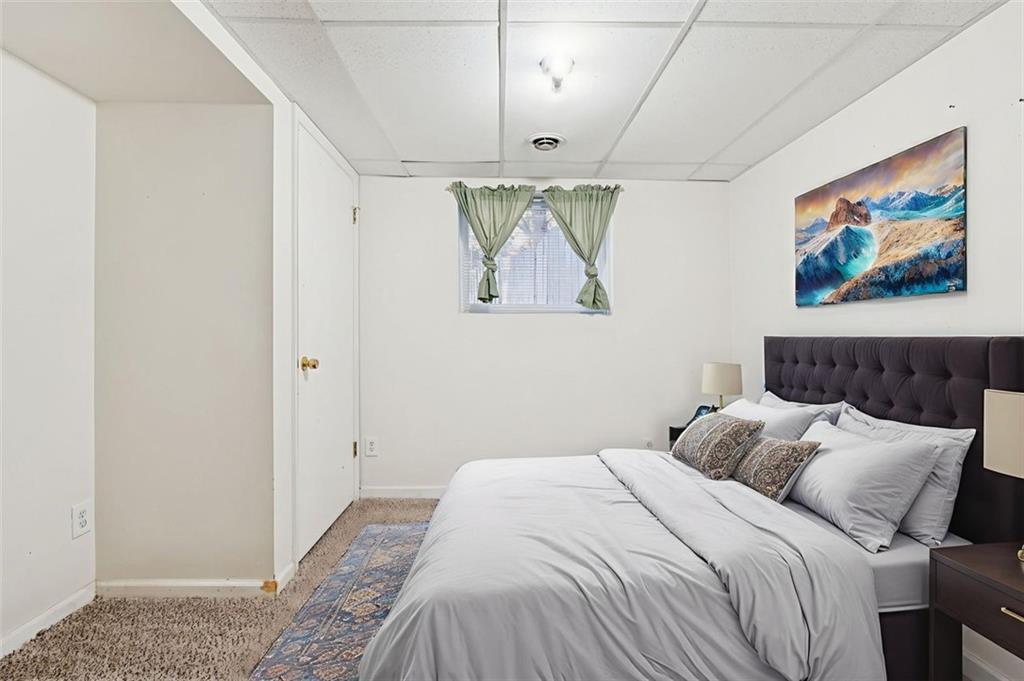 2470 Jakin Way Suwanee, GA 30024 - Photo 43 of 64 a bedroom with a bed and a painting on the wall