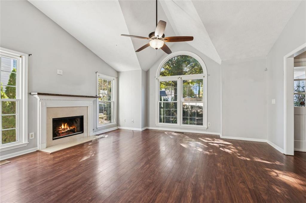 2470 Jakin Way Suwanee, GA 30024 - Photo 10 of 64 a view of an empty room with wooden floor fireplace and a window