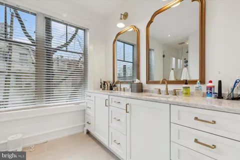 a bathroom with a double vanity sink a mirror and a bathtub