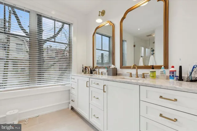 a bathroom with a double vanity sink a mirror and a bathtub