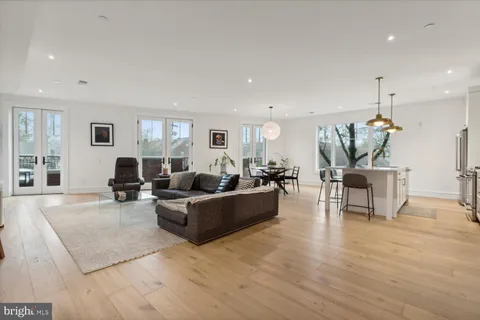 a living room with furniture and a dining table with wooden floor