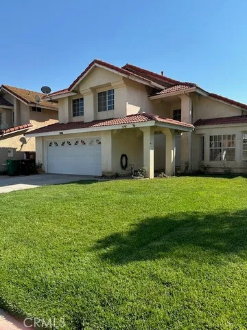 a front view of a house with a garden and yard