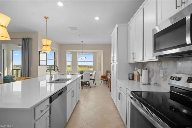 a large kitchen with stainless steel appliances granite countertop a sink a stove and a microwave