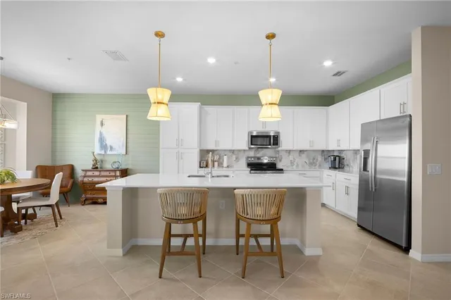 a kitchen with cabinets and chairs