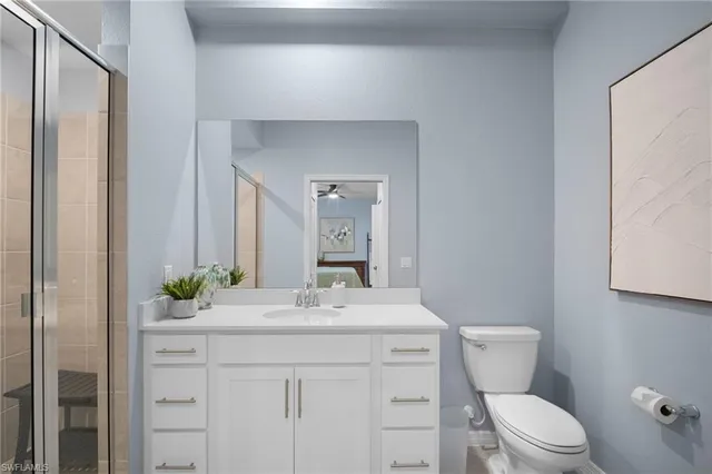 a bathroom with a sink vanity mirror and toilet
