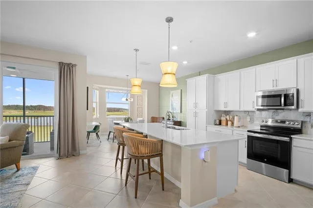 a kitchen with kitchen island granite countertop a sink a counter top stainless steel appliances and cabinets