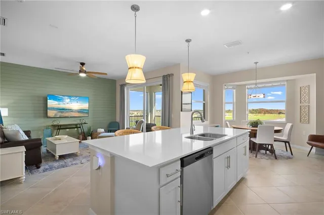 a open kitchen with stainless steel appliances granite countertop a sink a table and chairs