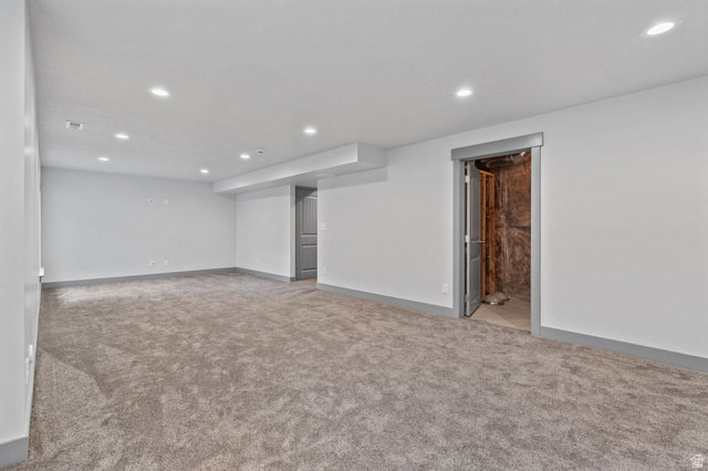 7822 North Copperbend Road Eagle Mountain, UT 84005 - Photo 41 of 46 Expansive carpeted room featuring recessed lighting, light-colored walls, and a gray door frame