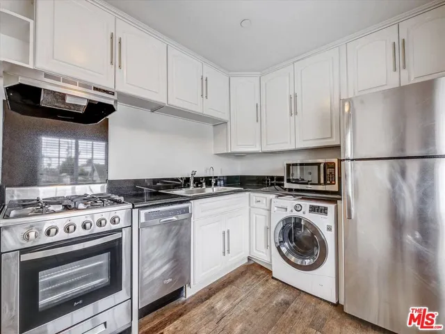 a kitchen with stainless steel appliances a stove a sink and a microwave
