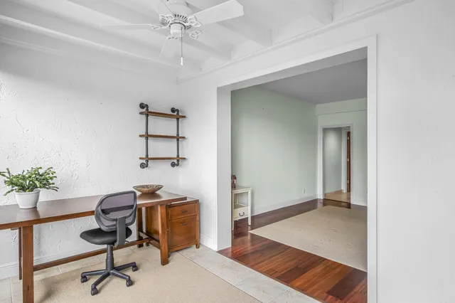 a view of a workspace with furniture and a window