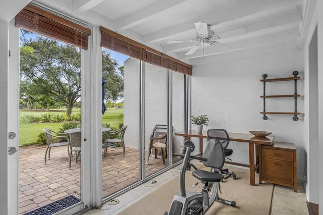 a view of a workspace with furniture and a window
