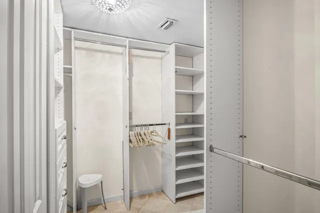 a view of walk in closet with empty racks