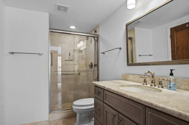 a bathroom with a granite countertop sink toilet and shower