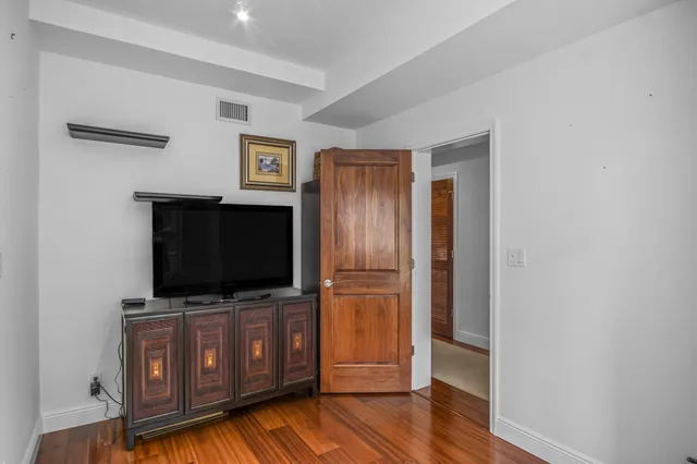 a view of a livingroom with wooden floor and flat screen tv