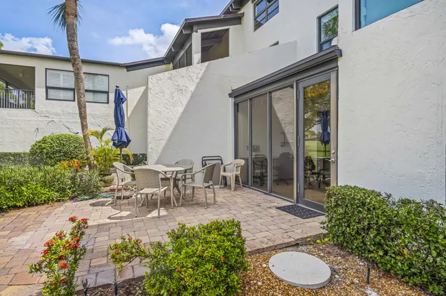 a view of a patio with table and chairs and potted plants