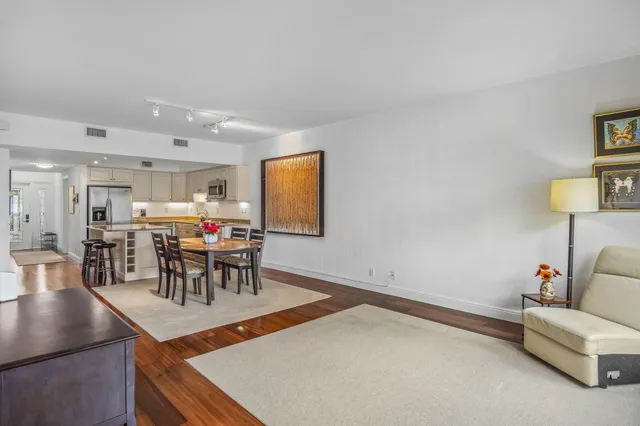 a living room with furniture a table and kitchen view