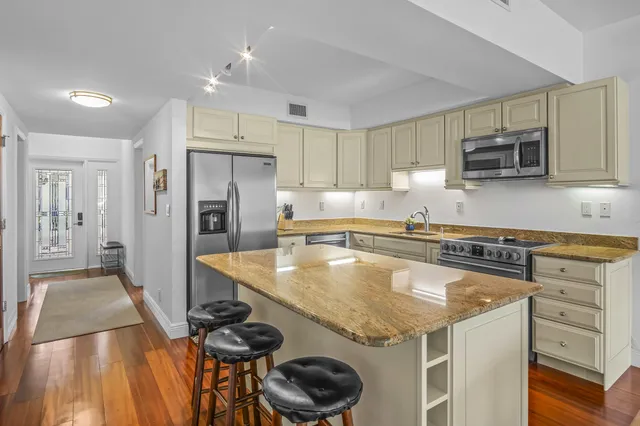a kitchen with stainless steel appliances granite countertop a sink stove and refrigerator