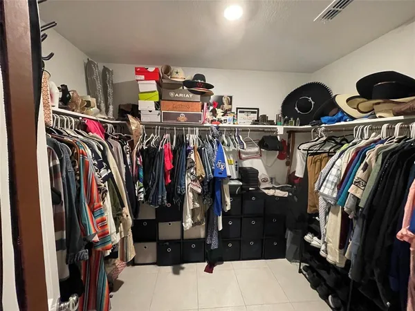 a view of walk in closet with clothes and shoes