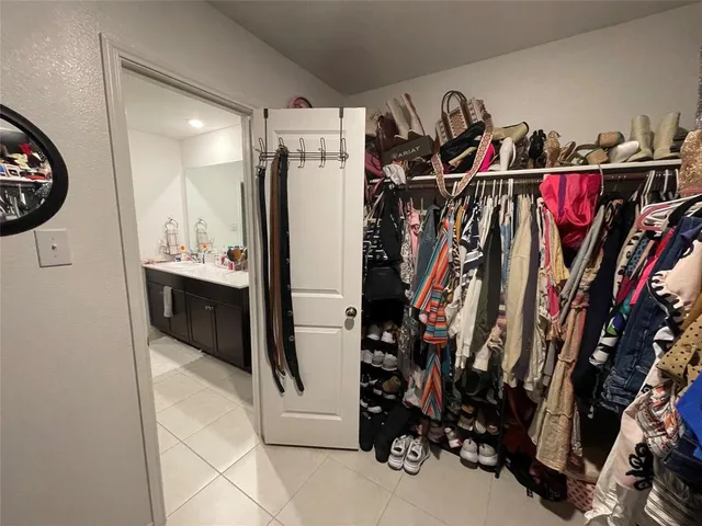 a view of walk in closet with clothes and shoes