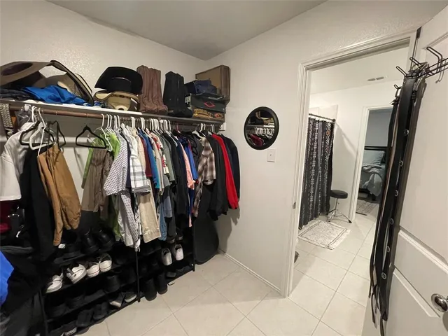 a view of walk in closet with clothes and shoes