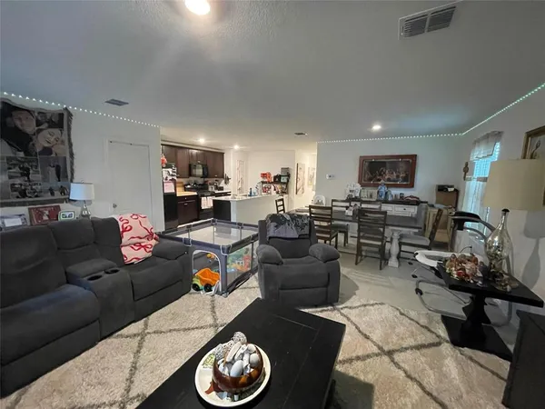 a living room with furniture kitchen view and a window