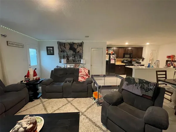 a living room with furniture and kitchen view