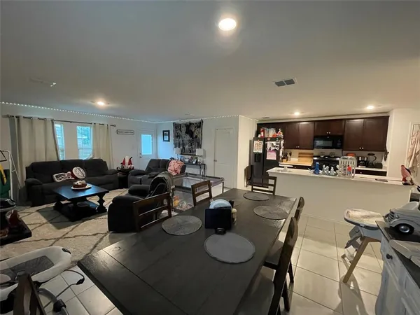 a living room with lots of furniture and a view of kitchen