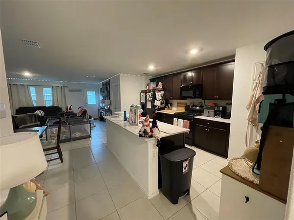 a living room with stainless steel appliances furniture and a view of kitchen