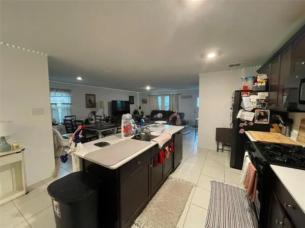 a large kitchen with kitchen island a sink counter space and a view of living room