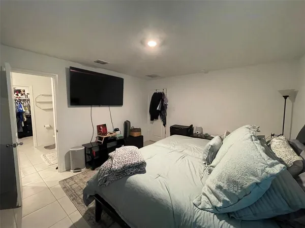 a bedroom with a bed a television and a large window