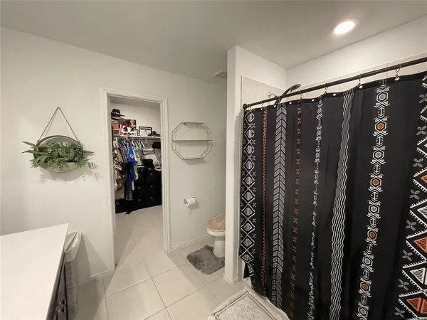a walk in closet with wooden floor