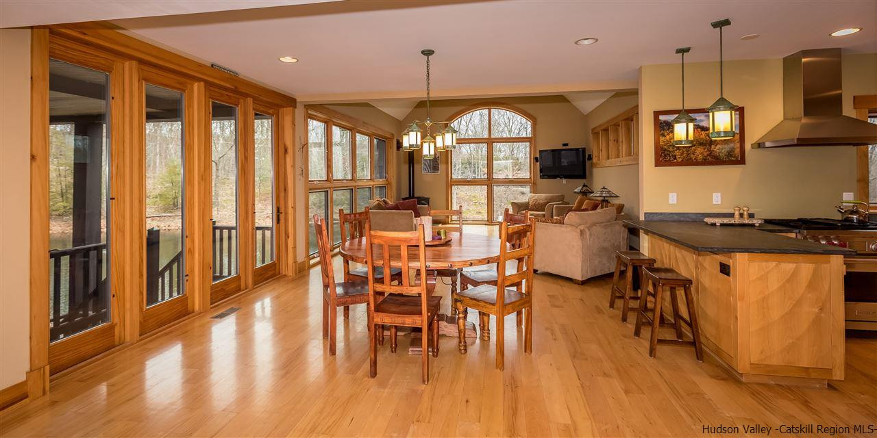 11 Sparkling Ridge Road New Paltz, NY 12561 - Photo 5 of 34 a kitchen with stainless steel appliances kitchen island granite countertop a stove a refrigerator a dining table and chairs with wooden floor