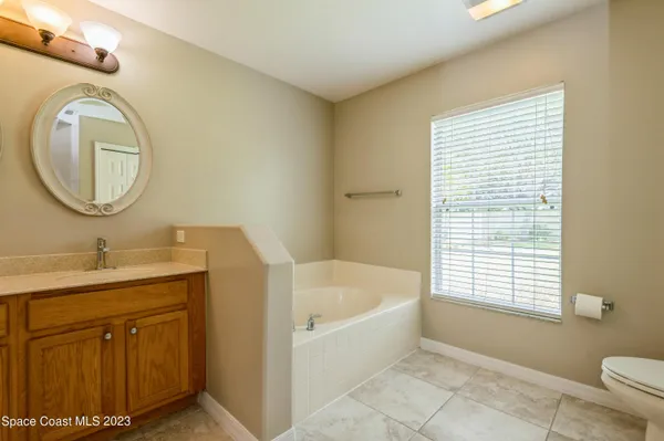 a bathroom with a granite countertop sink and a bathtub