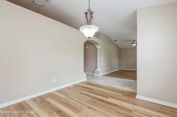 a view of a room with wooden floor and ceiling fan