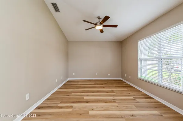 a view of empty room with window and ceiling fan