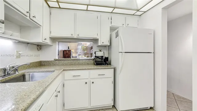 a kitchen with white cabinets and white appliances