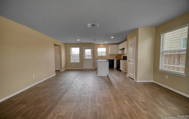 a view of wooden floor and windows in an empty room