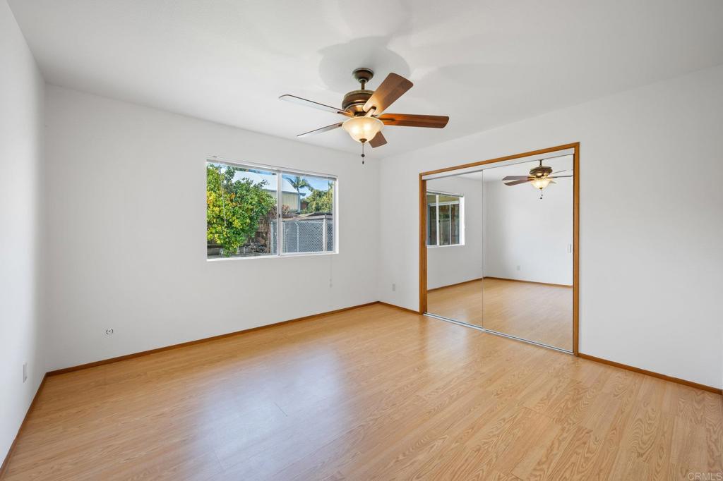 1054 Hermes Avenue Encinitas, CA 92024 - Photo 17 of 37 an empty room with wooden floor ceiling fan and windows