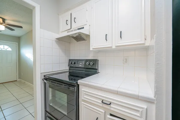 a kitchen with white cabinets and appliances