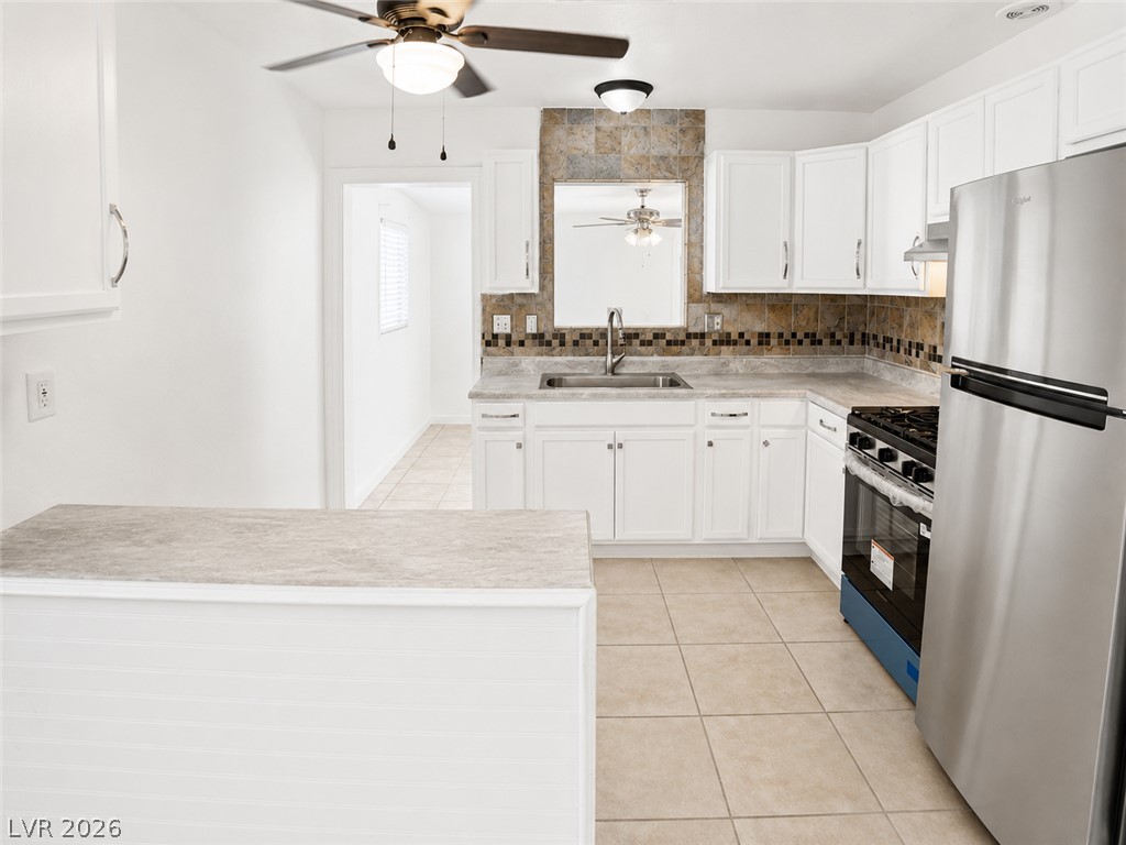 2870 South Sandhill Road Las Vegas, NV 89121 - Photo 31 of 64 A well-lit kitchen with sleek white cabinetry and modern stainless steel appliances.