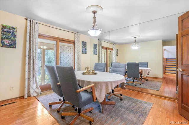 a view of a a dining room with furniture wooden floor and a chandelier