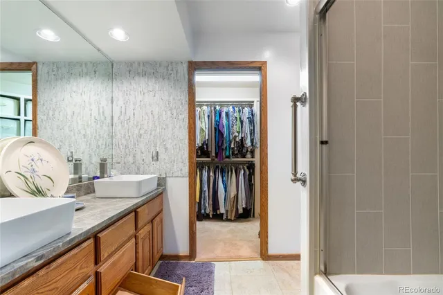 a en suite bathroom with a granite countertop sink and a mirror