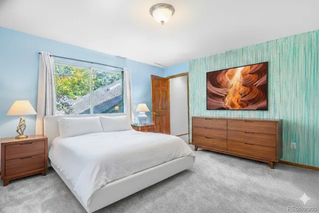 a bedroom with a bed and a painting on the wall