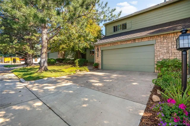 a view of yellow house with outdoor space and garden in the background