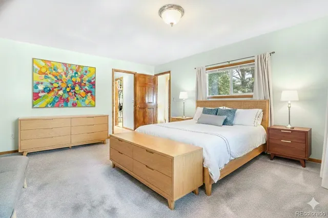 a bedroom with a bed and a painting on the wall