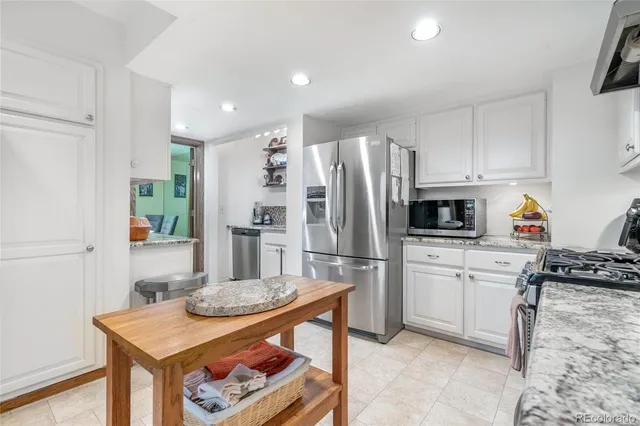 a kitchen with stainless steel appliances granite countertop a refrigerator stove microwave and sink