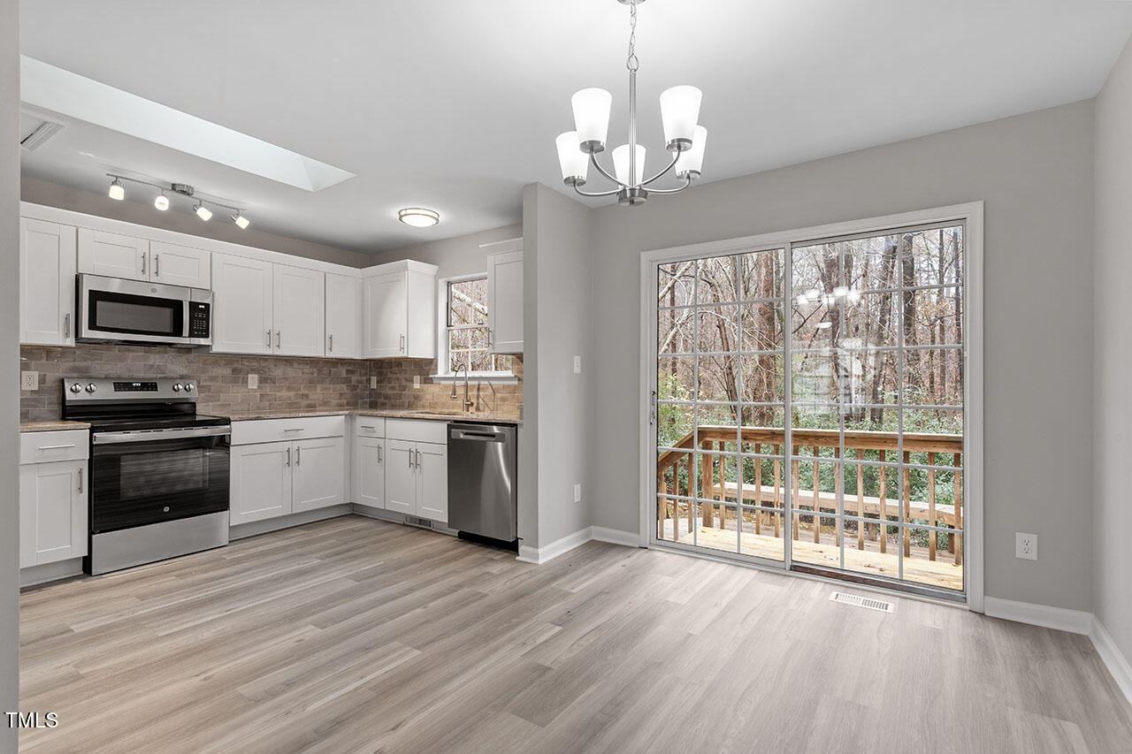 8341 Wynewood Court Raleigh, NC 27616 - Photo 13 of 35 a large kitchen with hardwood floor stainless steel appliances and cabinets